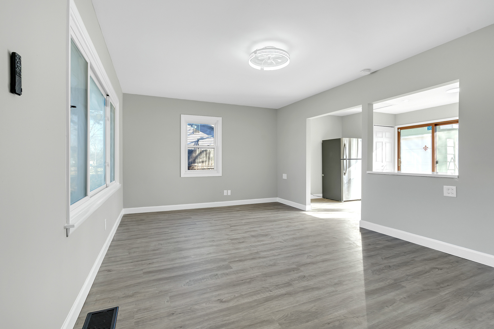 104 Louis Road Joliet, IL 60433 - Photo 2 of 11 a view of an empty room with window and wooden floor