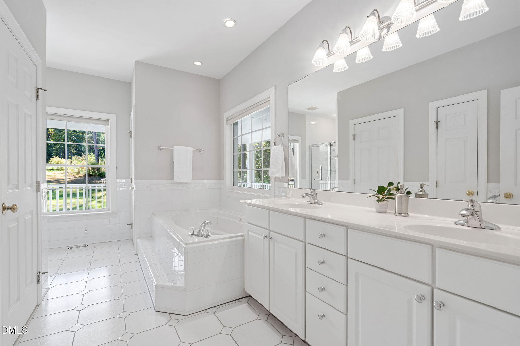 9916 Bonsal Crossing Road New Hill, NC 27562 - Photo 29 of 80 a spacious bathroom with a double vanity sink a mirror a and a bathtub