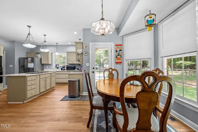 a dining room with furniture a chandelier and wooden floor