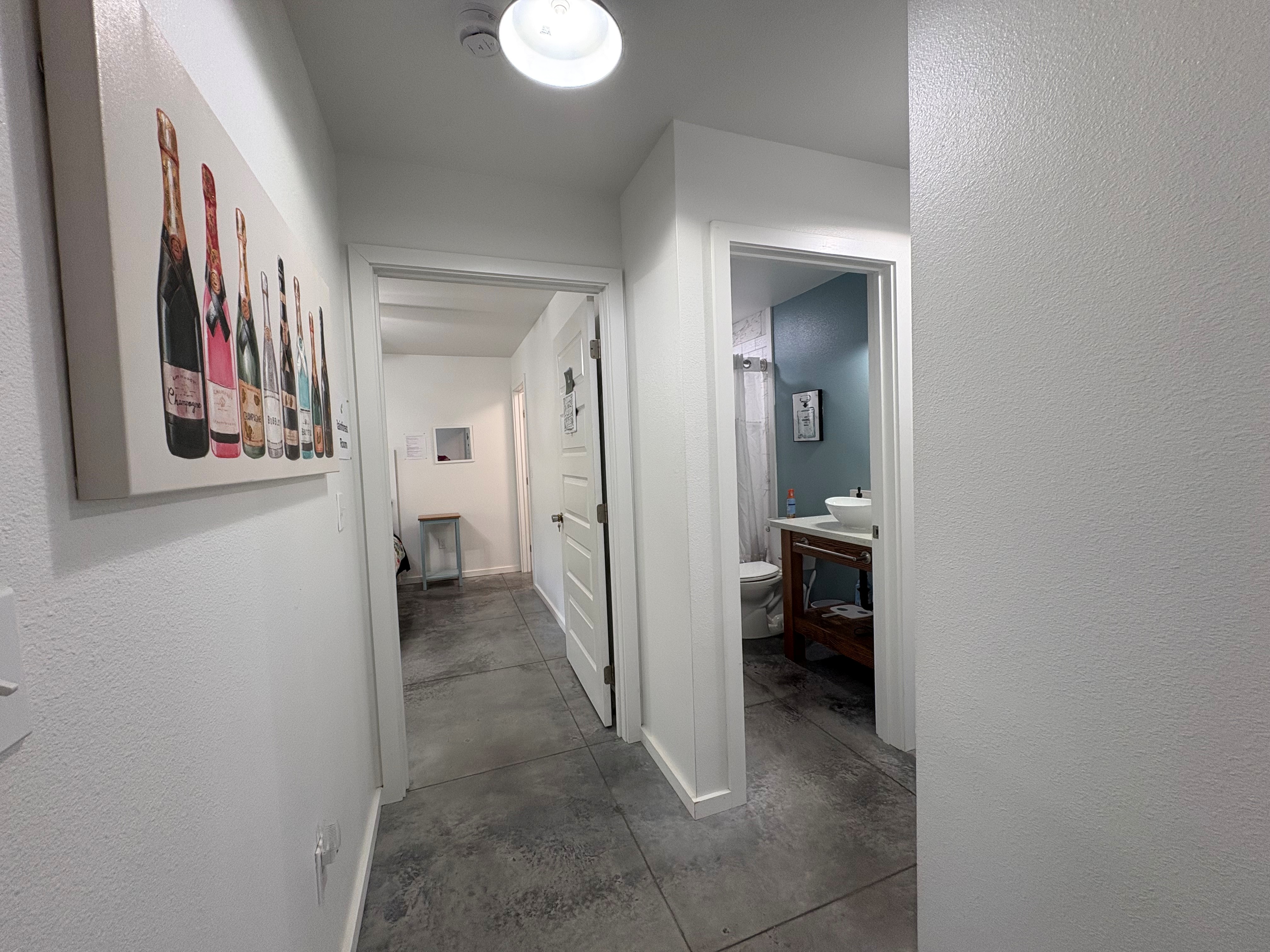 11-3083 Kaleponi Road Mountain View, HI 96771 - Photo 14 of 28 a view of a hallway with wooden floor and a bathroom