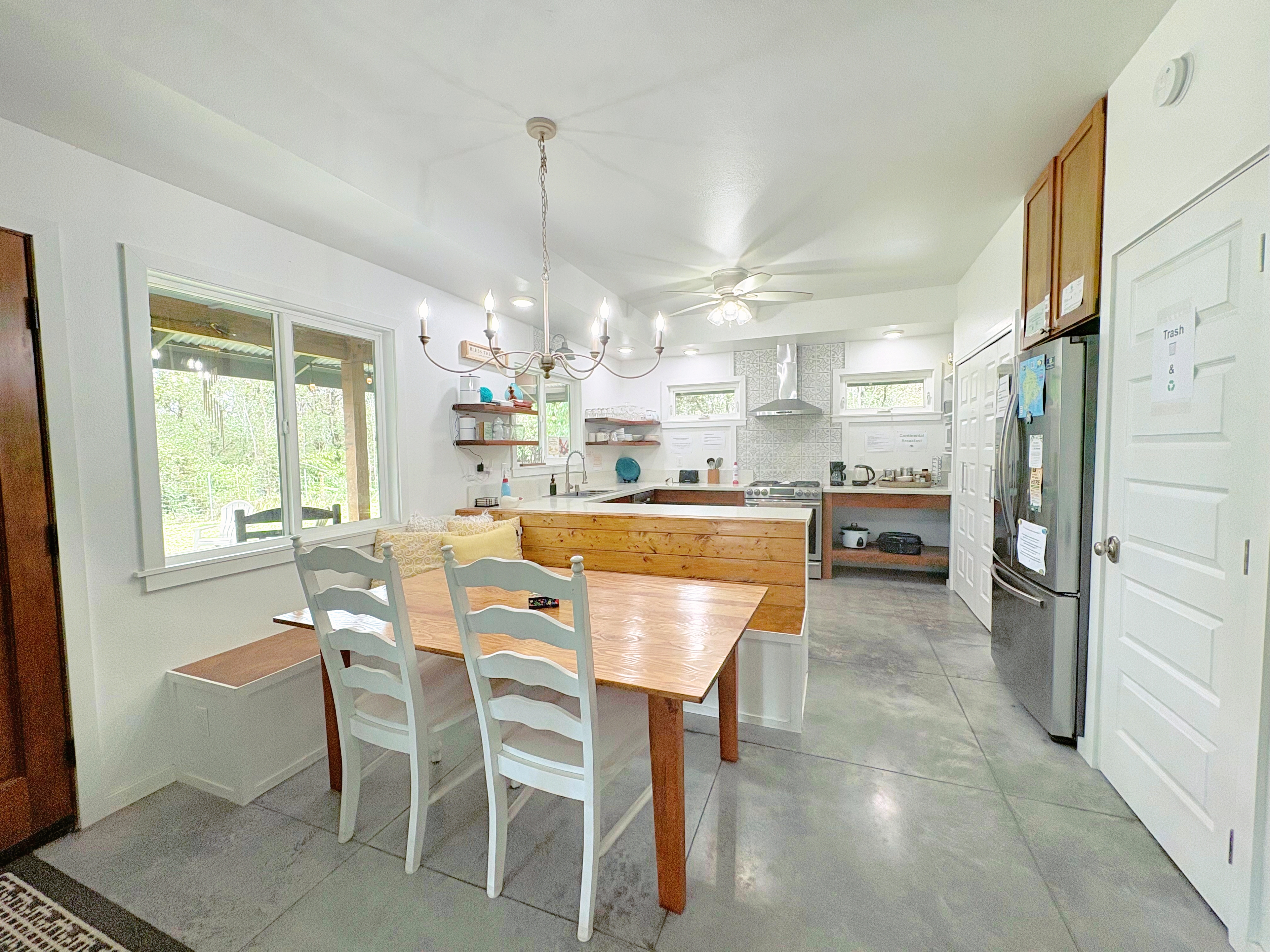 11-3083 Kaleponi Road Mountain View, HI 96771 - Photo 2 of 28 a dining room with stainless steel appliances kitchen island granite countertop a table chairs and a view of living room