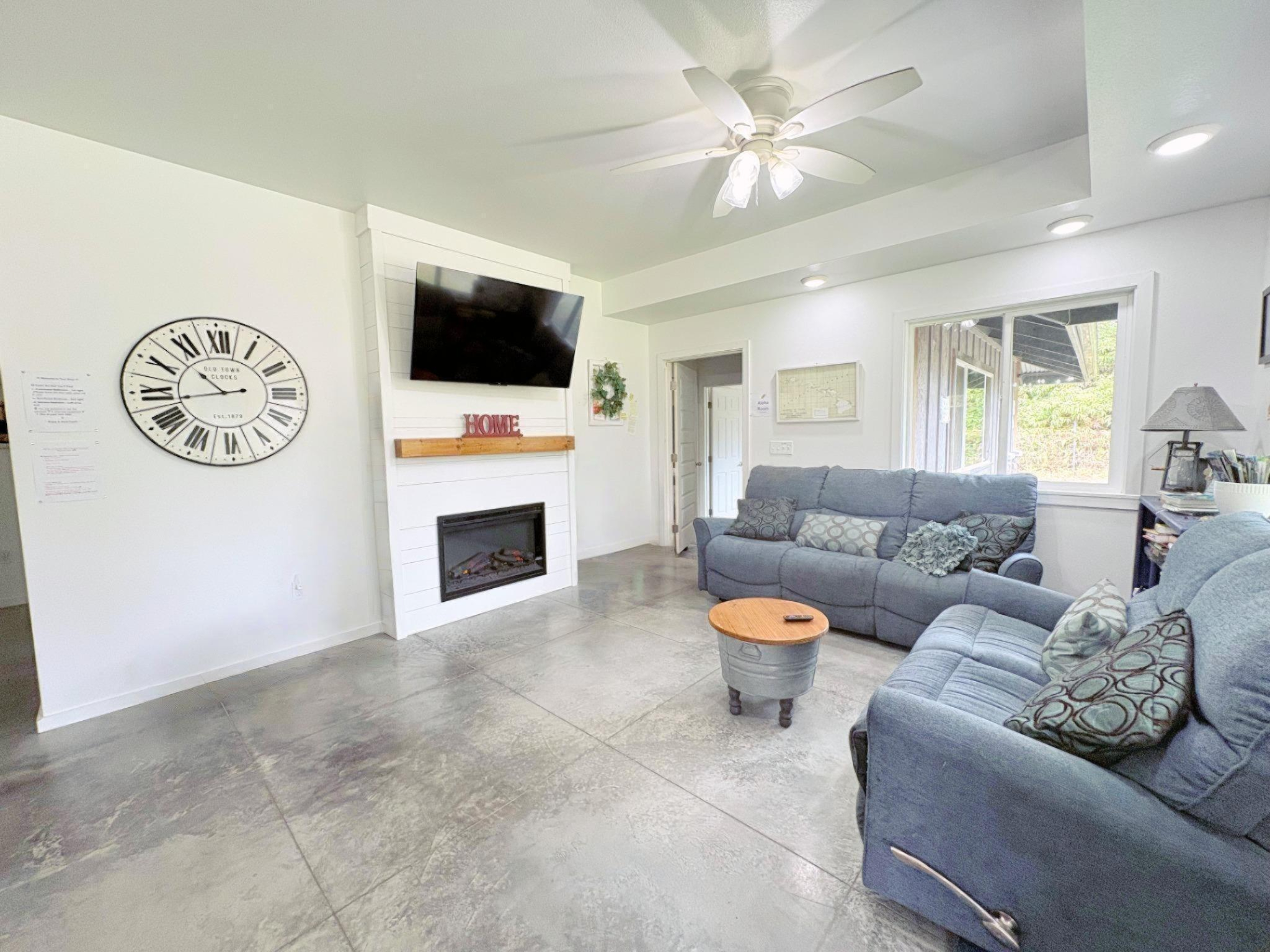 11-3083 Kaleponi Road Mountain View, HI 96771 - Photo 4 of 28 a living room with furniture a flat screen tv and a fireplace