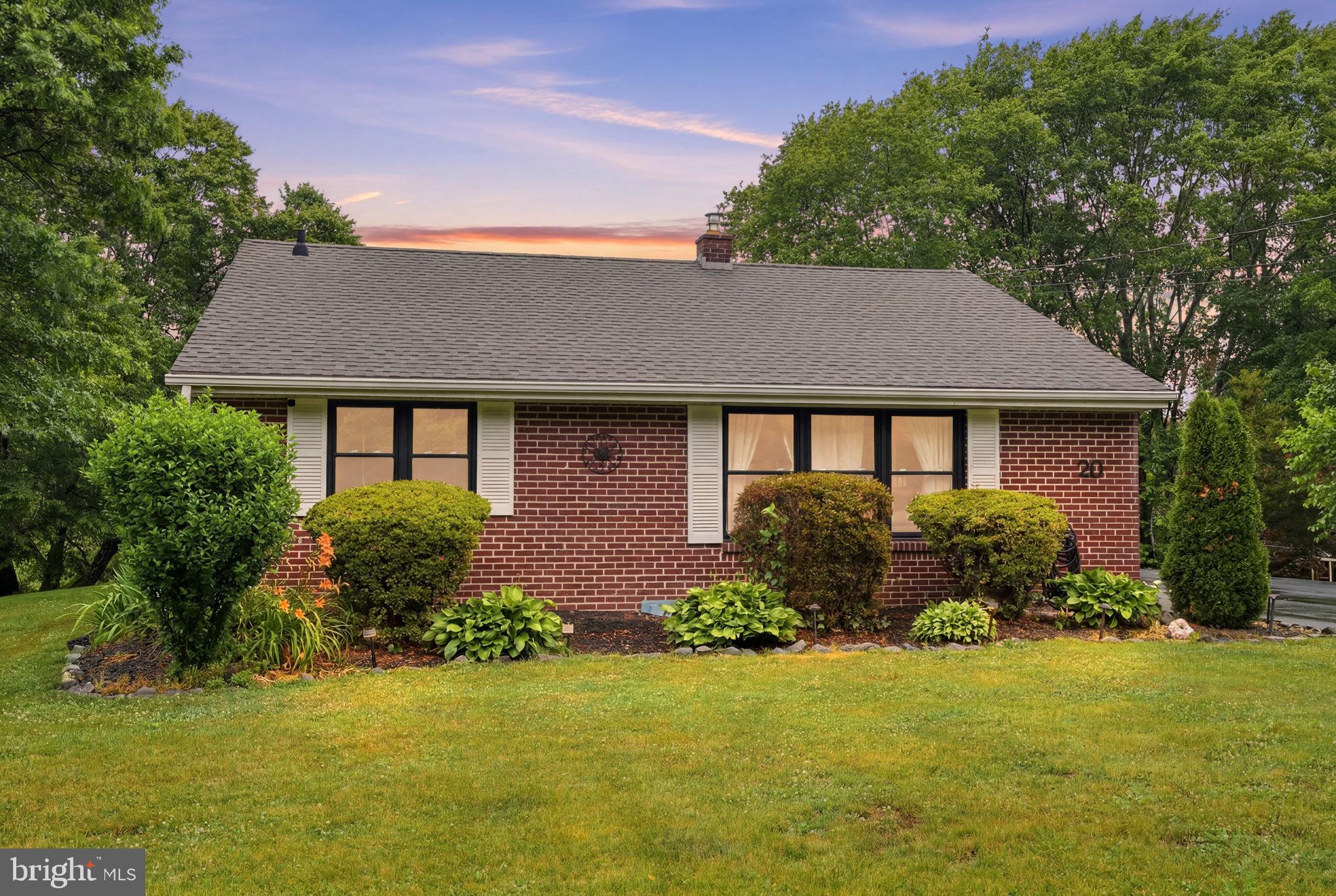 Charming brick home with lush greenery.