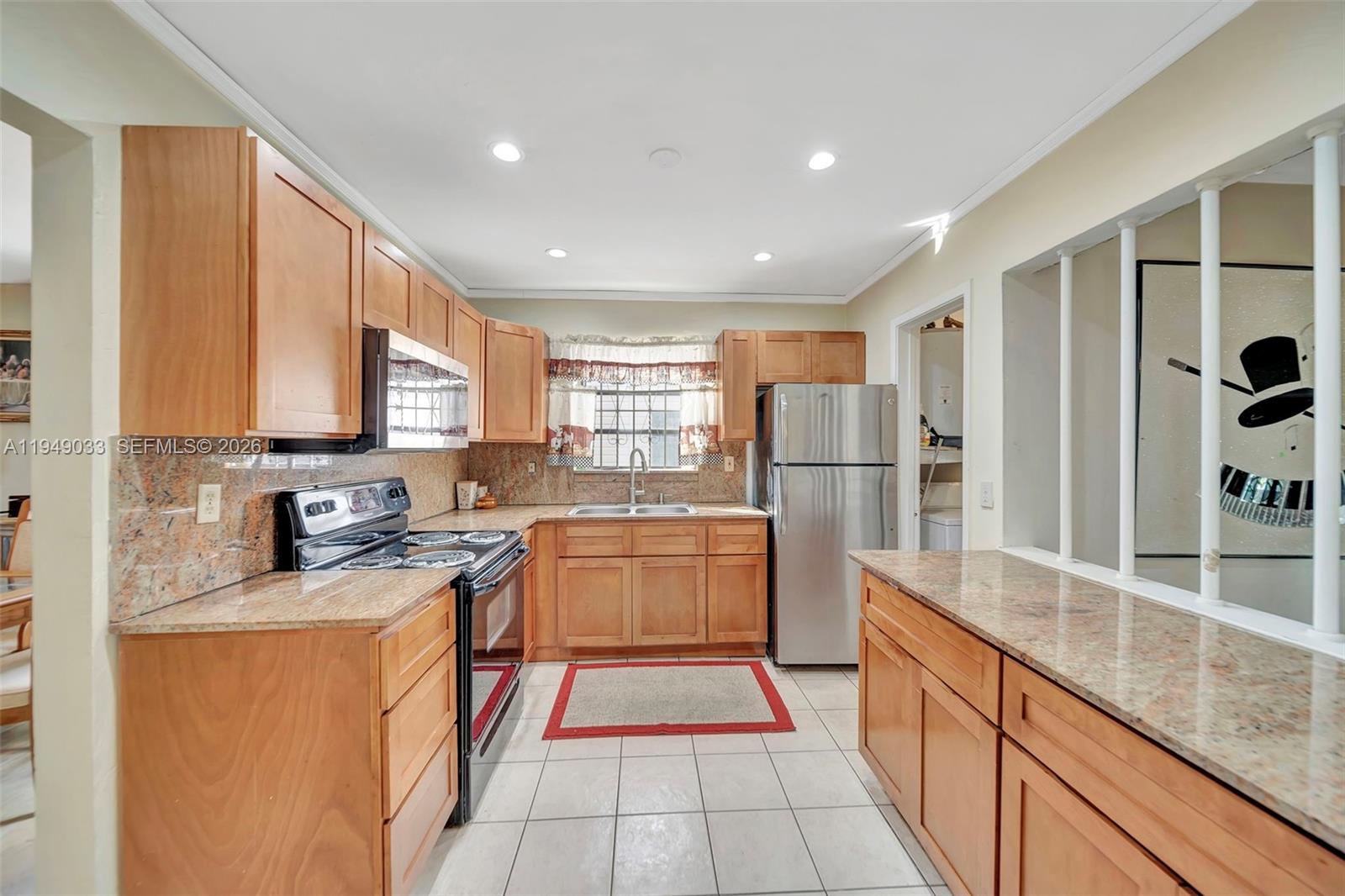 244 Northwest 43rd Street Miami, FL 33127 - Photo 5 of 29 a kitchen with stainless steel appliances granite countertop a refrigerator and a stove top oven