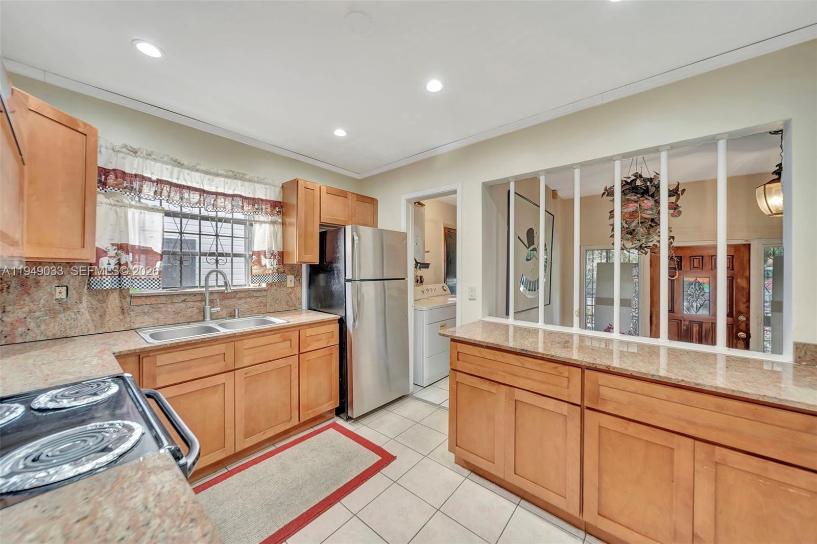 244 Northwest 43rd Street Miami, FL 33127 - Photo 6 of 29 a kitchen with stainless steel appliances granite countertop a refrigerator and a sink