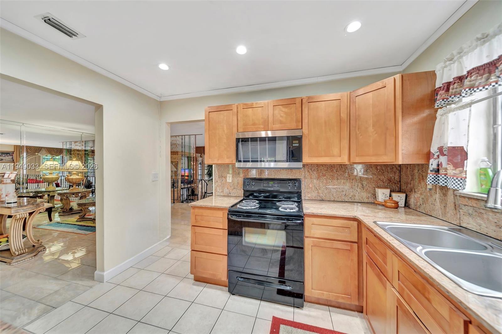 244 Northwest 43rd Street Miami, FL 33127 - Photo 7 of 29 a kitchen with granite countertop a stove sink and cabinets