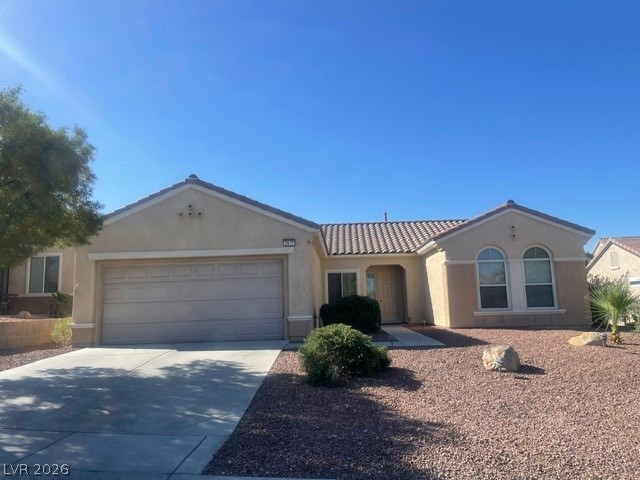 A desert-friendly landscape surrounds this charming single-story residence, featuring an integrated two-car garage.