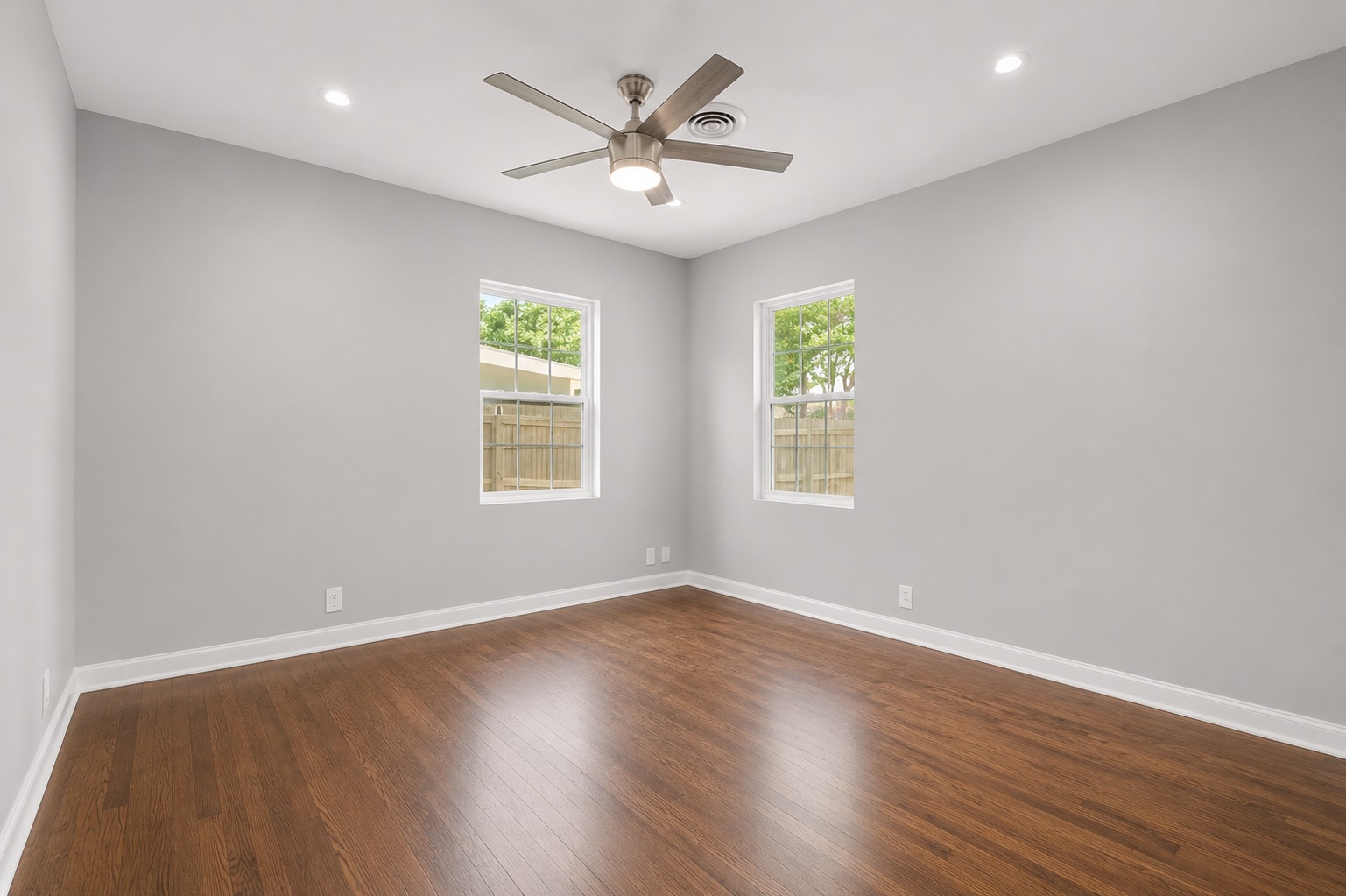 2105 Fortview Road Austin, TX 78704 - Photo 30 of 37 Two windows allow ample light into this bedroom, featuring beautiful hardwood flooring and a modern ceiling fan.