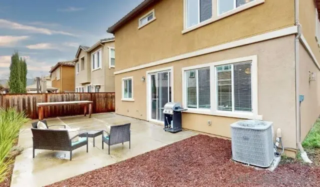 a view of a patio with couches table and chairs and potted plants