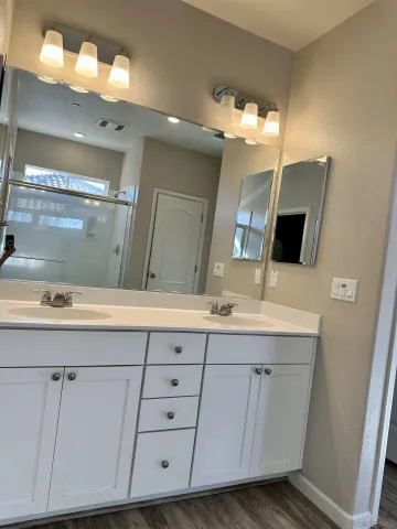 a bathroom with a double vanity sink and a mirror