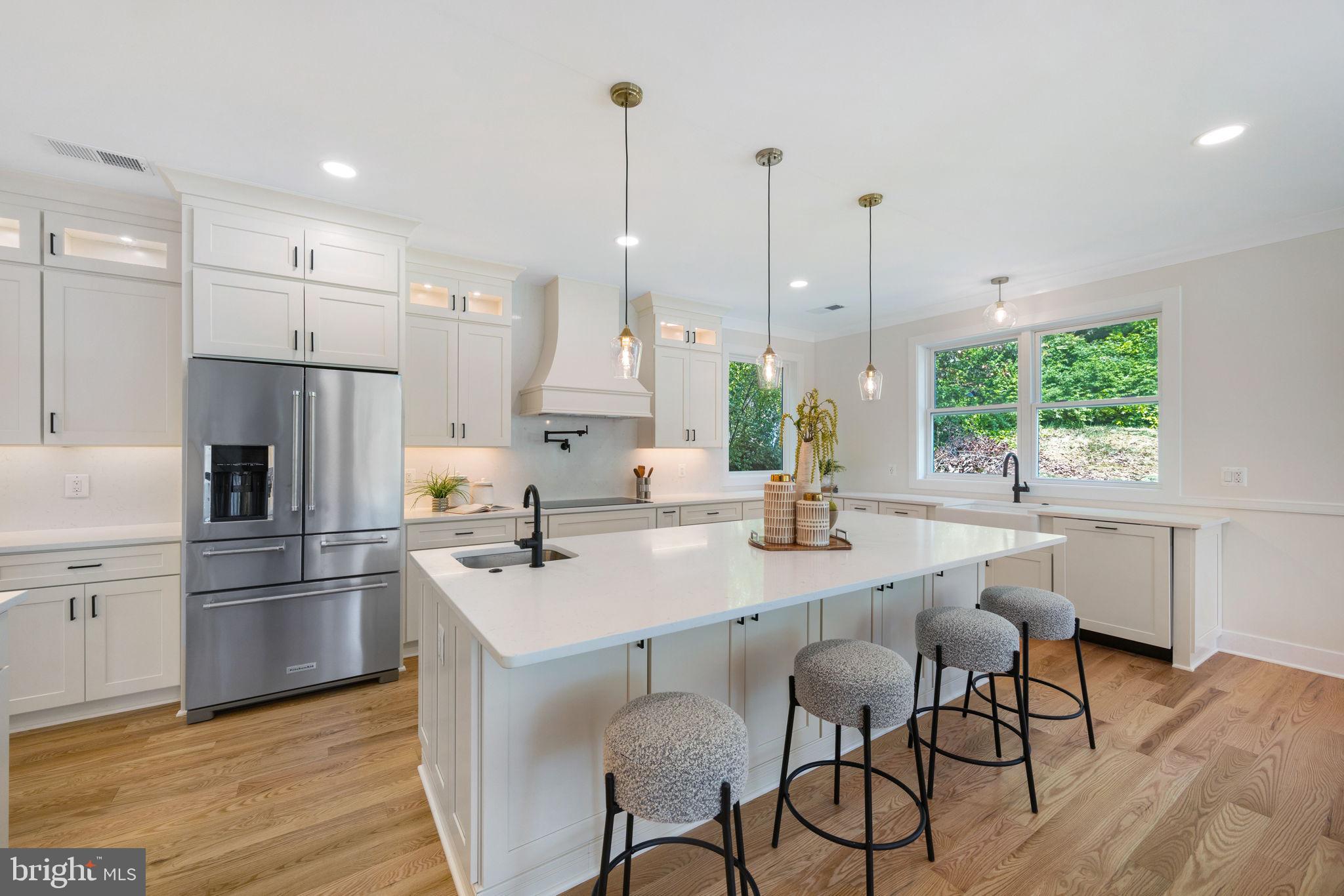 132 North Earley Street Alexandria, VA 22304 - Photo 4 of 44 a kitchen with stainless steel appliances kitchen island granite countertop a sink a stove a refrigerator and island with wooden floor