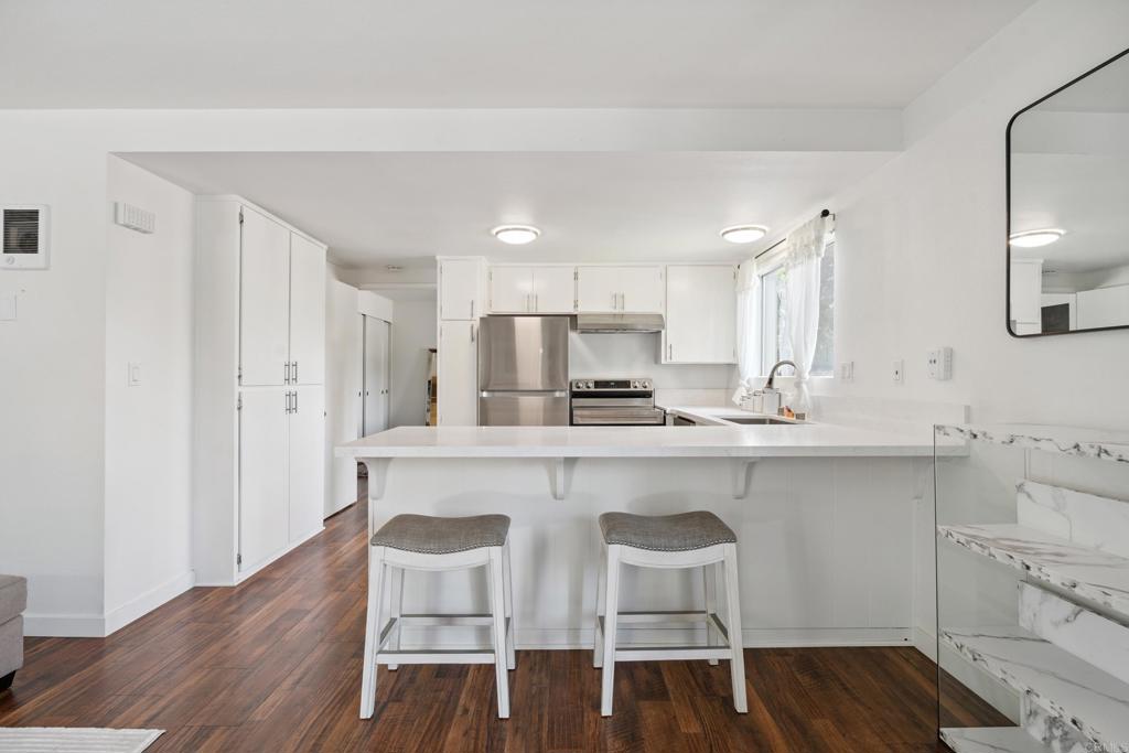 155 Rosebay Drive, Unit 31 Encinitas, CA 92024 - Photo 9 of 31 a kitchen with stainless steel appliances a dining table chairs sink and cabinets
