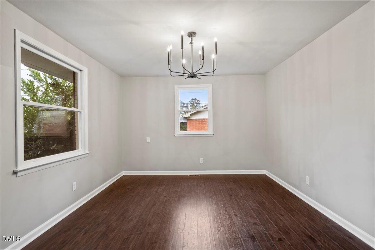 816 Peyton Street Raleigh, NC 27610 - Photo 12 of 29 a room with wooden floor chandelier and window