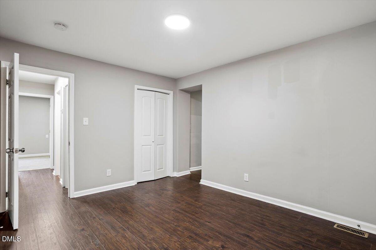 816 Peyton Street Raleigh, NC 27610 - Photo 14 of 29 a view of an empty room with wooden floor