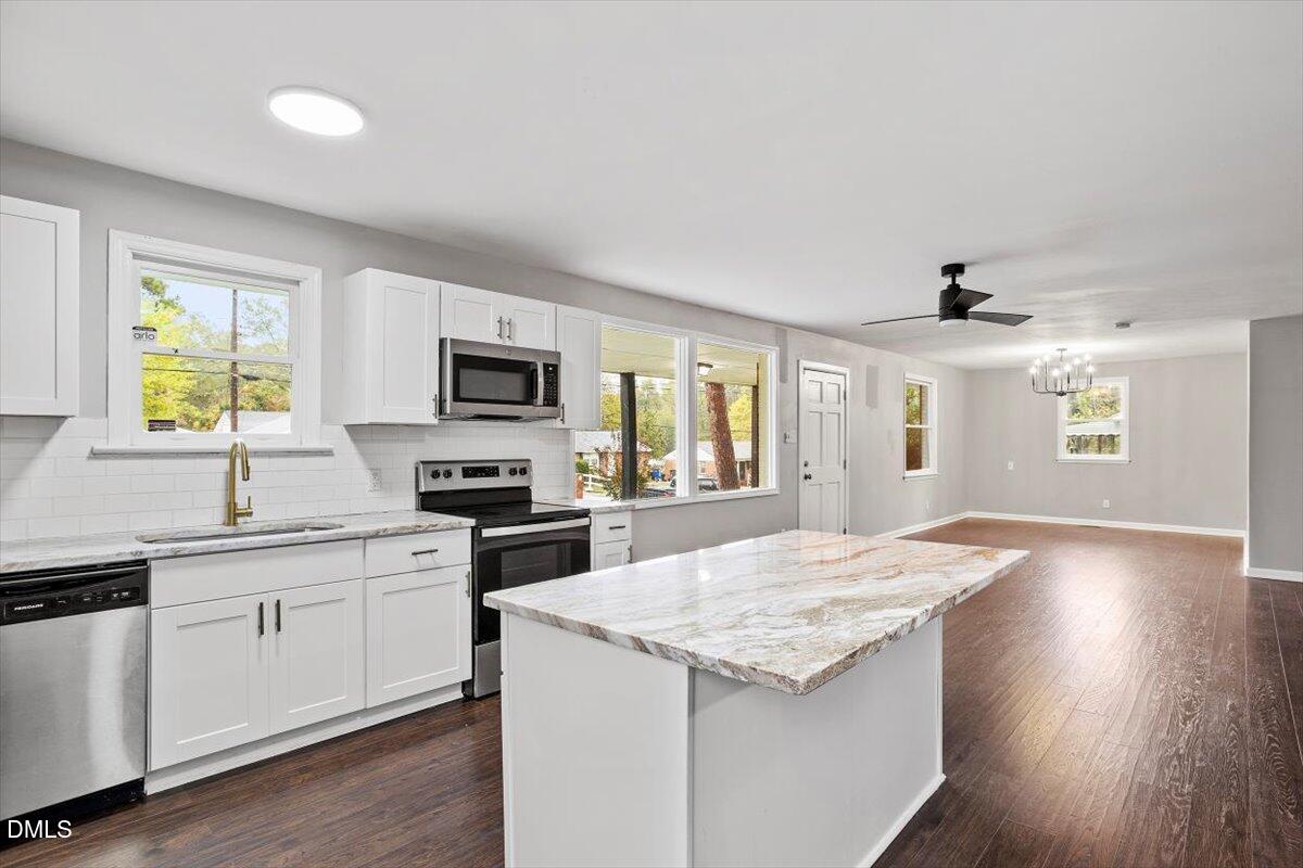 816 Peyton Street Raleigh, NC 27610 - Photo 4 of 29 a kitchen with granite countertop a sink appliances cabinets and wooden floor