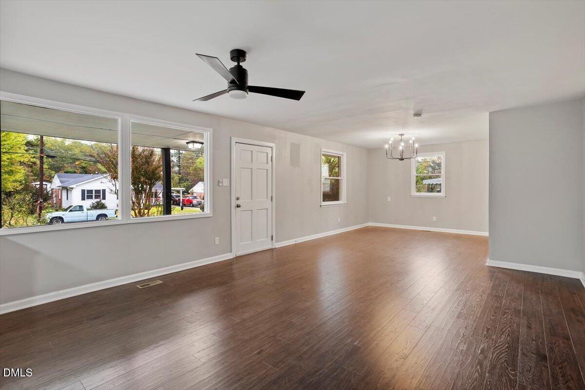 816 Peyton Street Raleigh, NC 27610 - Photo 9 of 29 a view of an empty room with wooden floor and a window