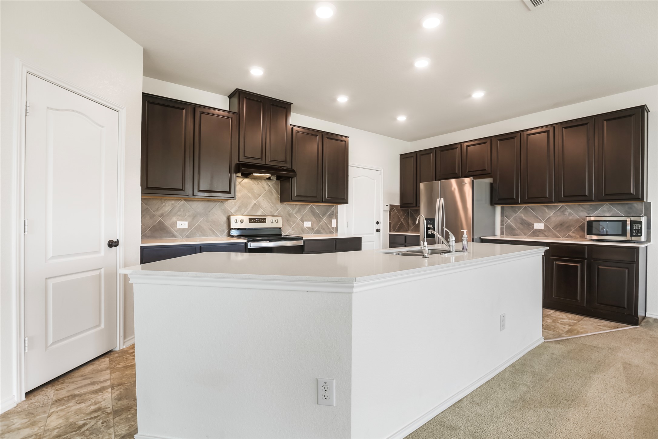18917 Rushmore Street Manor, TX 78653 - Photo 5 of 28 a kitchen with kitchen island granite countertop stainless steel appliances and cabinets