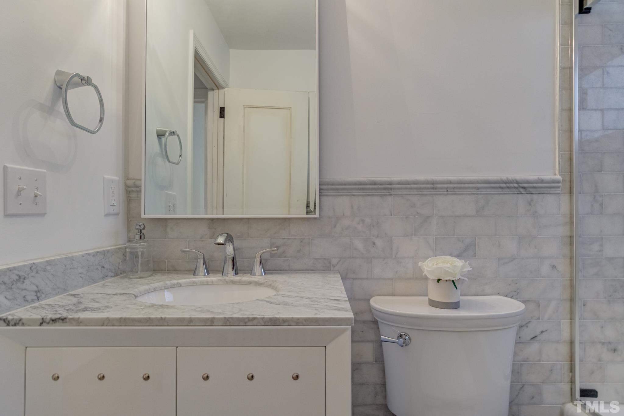 1212 Watauga Street Raleigh, NC 27604 - Photo 29 of 33 a bathroom with a granite countertop sink a toilet and a mirror