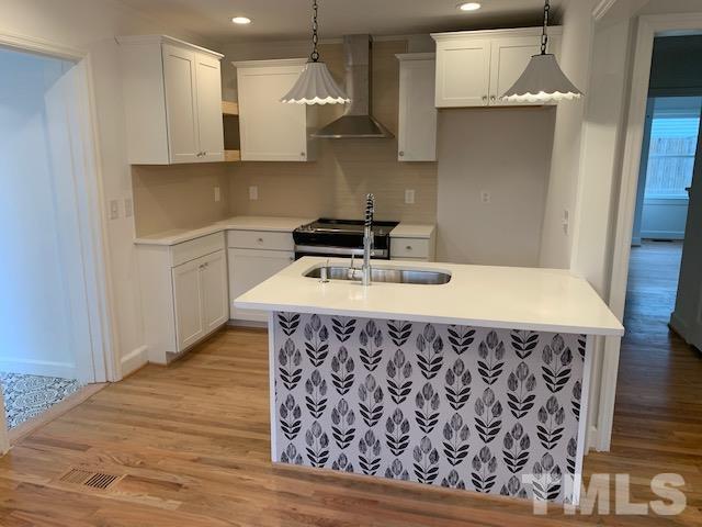 1212 Watauga Street Raleigh, NC 27604 - Photo 8 of 33 a kitchen with a wooden floor and a sink