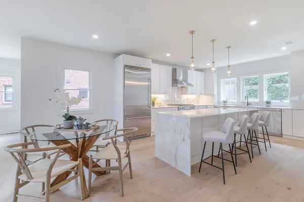 a kitchen with kitchen island granite countertop wooden cabinets and a dining table