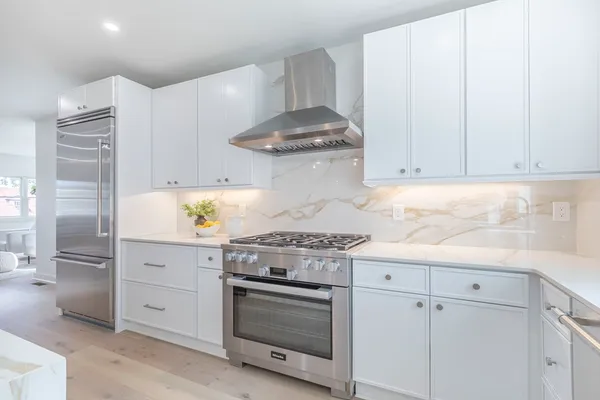 a kitchen with granite countertop white cabinets and stainless steel appliances