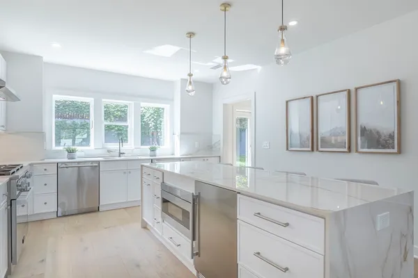 a large white kitchen with a large window