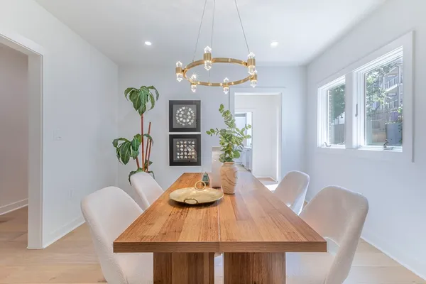 a view of a dining room with furniture a chandelier and wooden floor