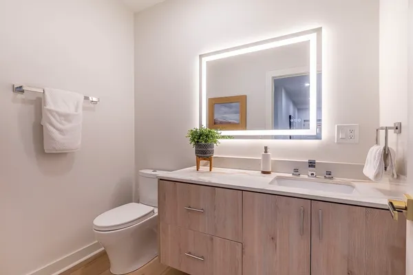 a bathroom with a toilet sink and mirror