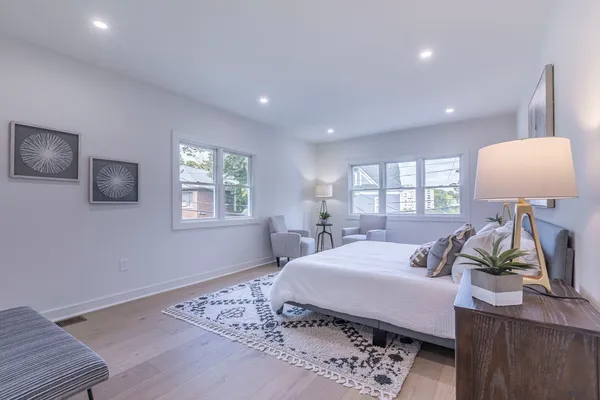 a bedroom with a bed a mirror and window