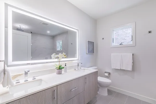 a bathroom with a sink a toilet and mirror