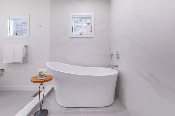 a white bath tub sitting next to a toilet