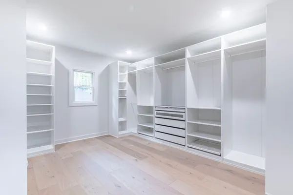 a view of walk in closet with empty racks
