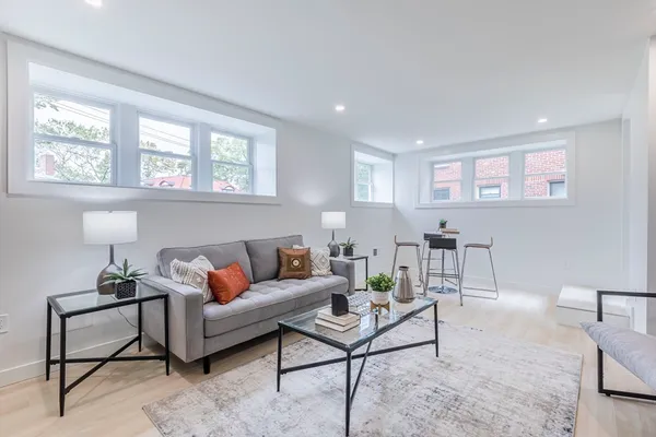 a living room with furniture a rug and a window