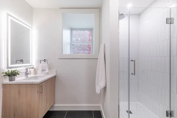 a bathroom with a sink a mirror and a shower