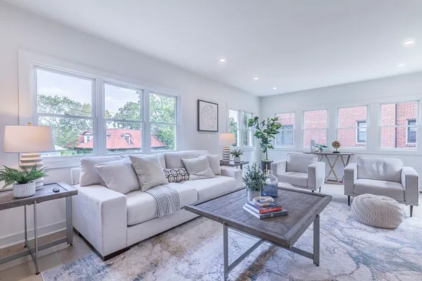 a living room with furniture potted plant and a large window