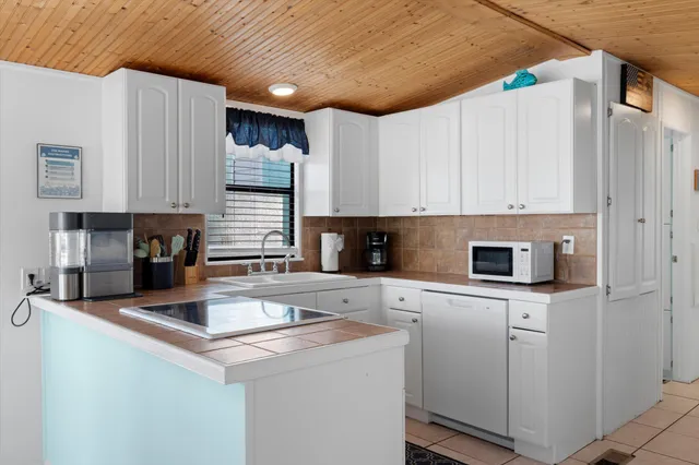 a view of a kitchen with stainless steel appliances granite countertop a stove and a refrigerator