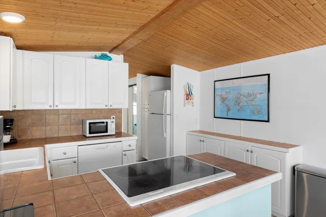 a kitchen with stainless steel appliances granite countertop a refrigerator and a stove top oven