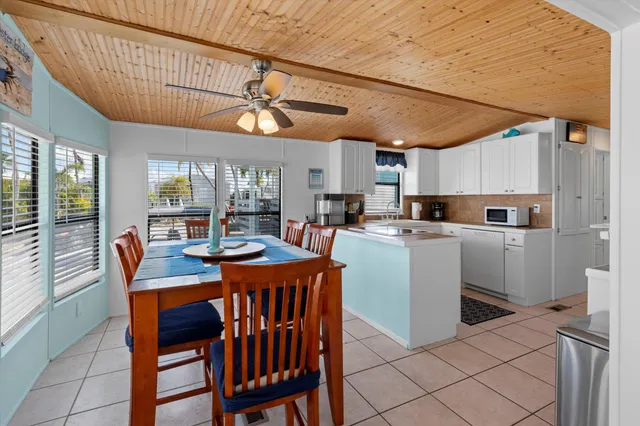 a kitchen with stainless steel appliances a stove top oven a sink a dining table and chairs