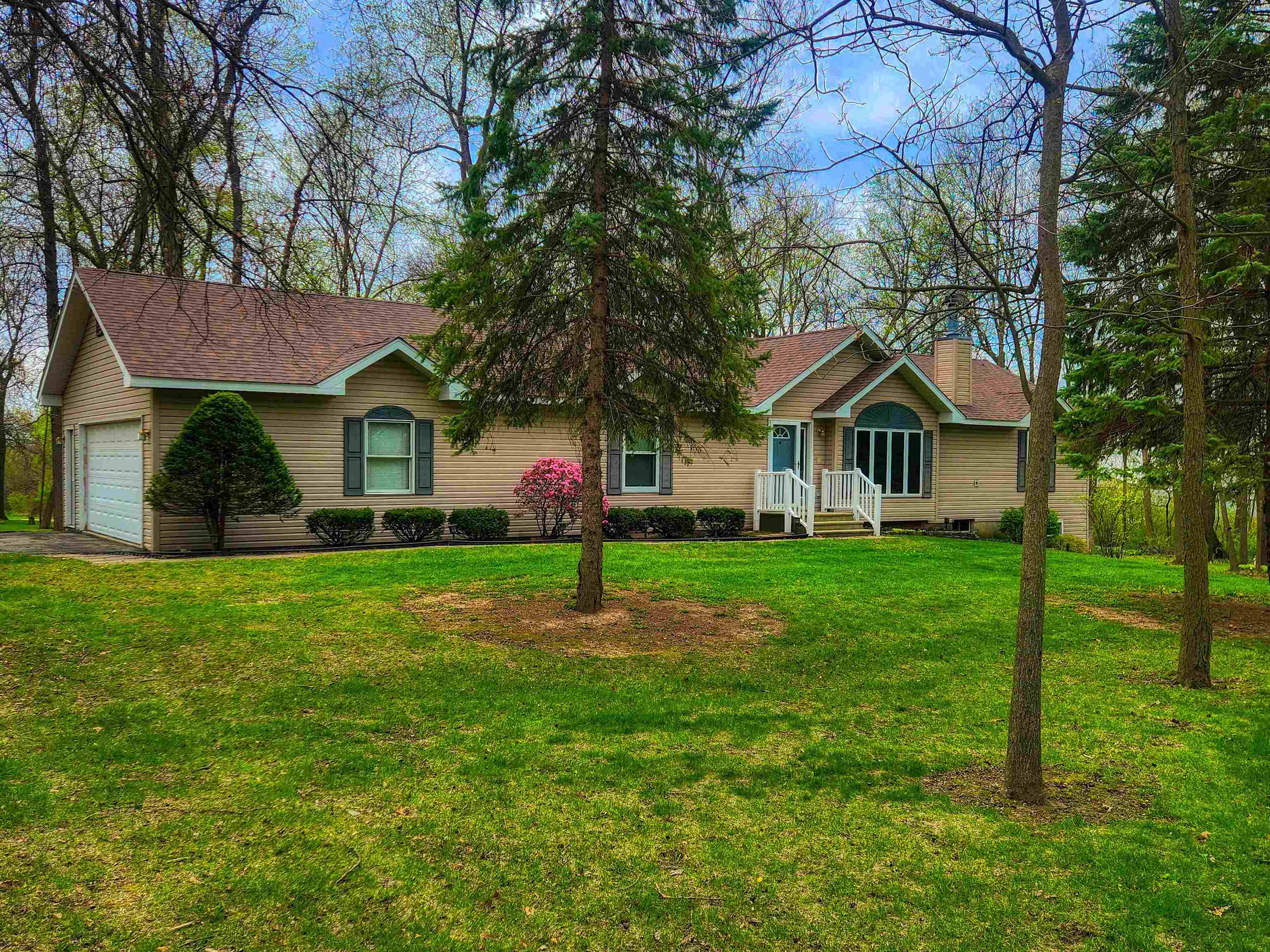 a front view of house with yard and green space