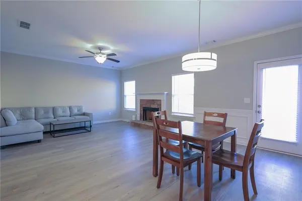 a view of a dining room with furniture a chandelier and wooden floor