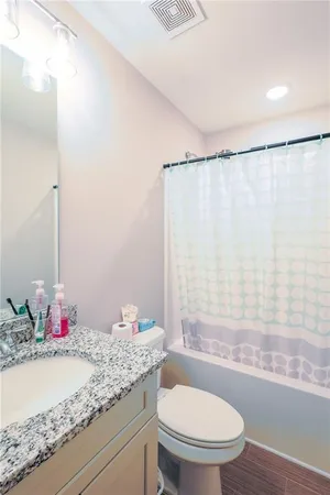 a bathroom with a granite countertop sink toilet and shower