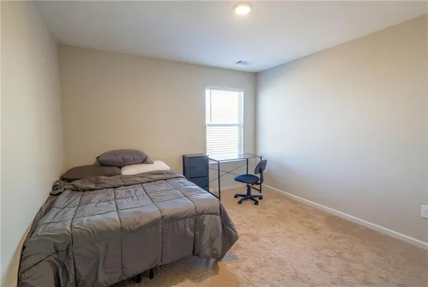 a bedroom with a bed a table and a window