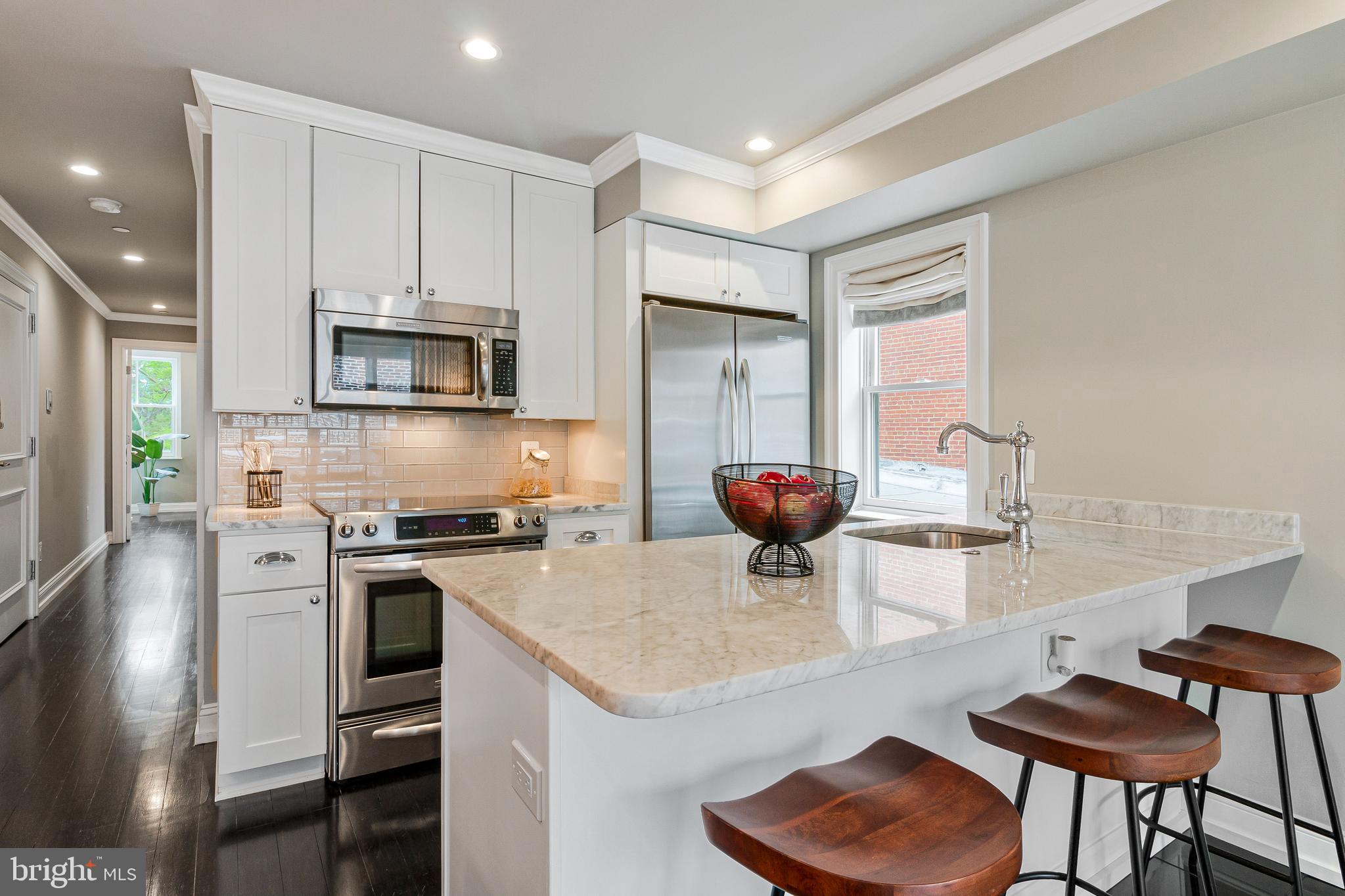 418 Seward Square Southeast, Unit 3 Washington, DC 20003 - Photo 6 of 16 a kitchen with a stove a refrigerator and a dining table