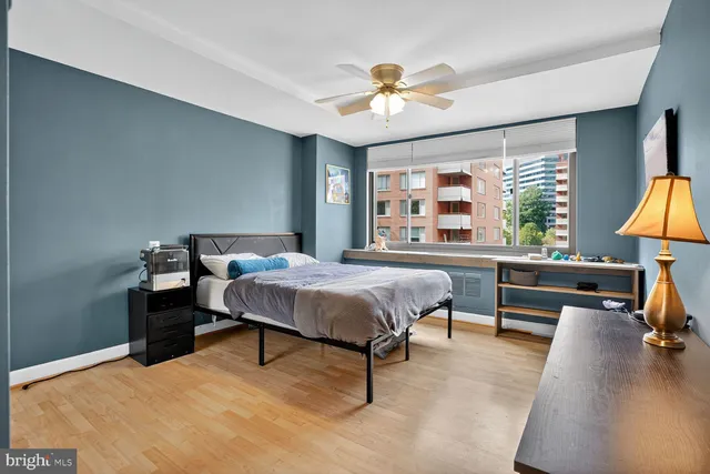 a spacious bedroom with a bed a chandelier and a large window