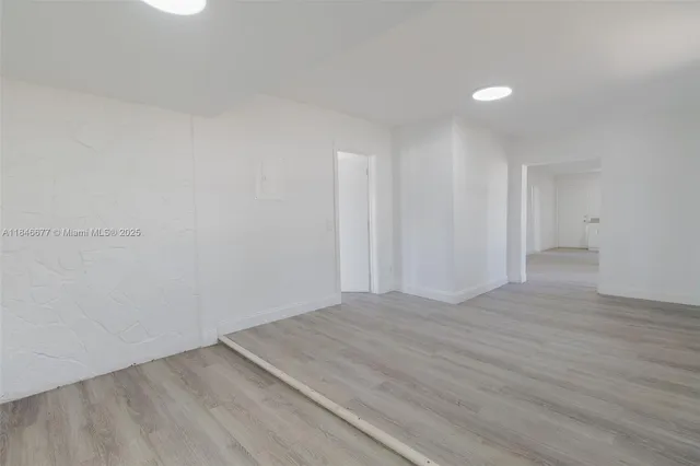 a view of an empty room and wooden floor