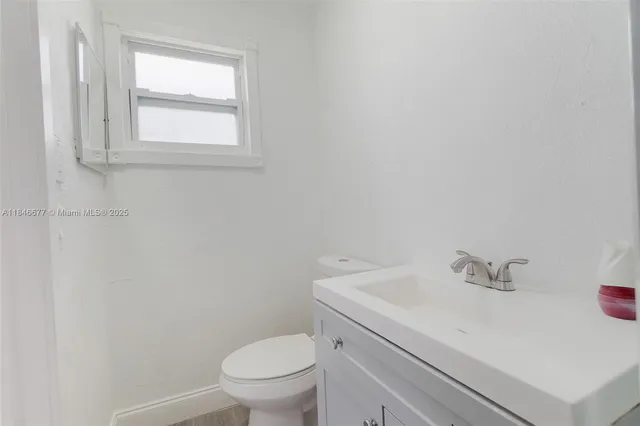a bathroom with a sink a toilet and a window