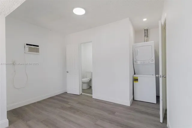 a view of an empty room with wooden floor and closet