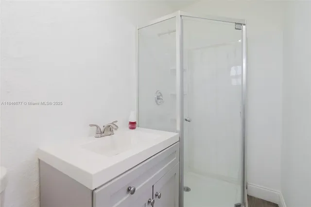 a bathroom with a sink a mirror and a shower