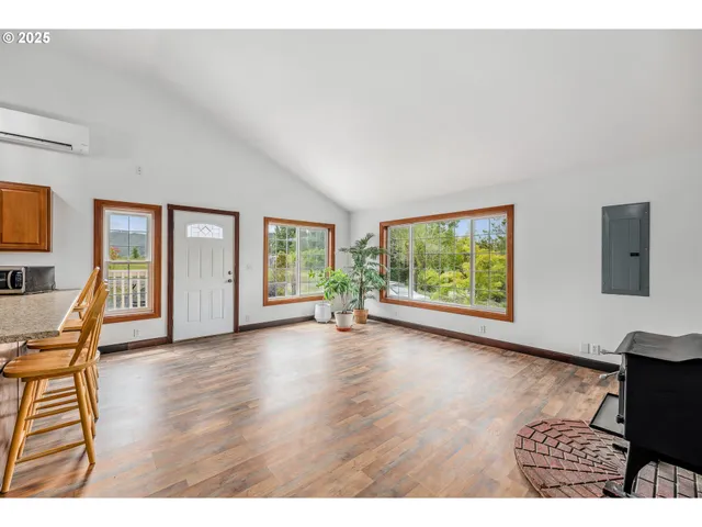 a view of an empty room with wooden floor and windows