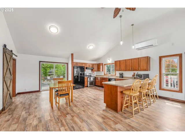 a living room with lots of furniture and kitchen view with wooden floor